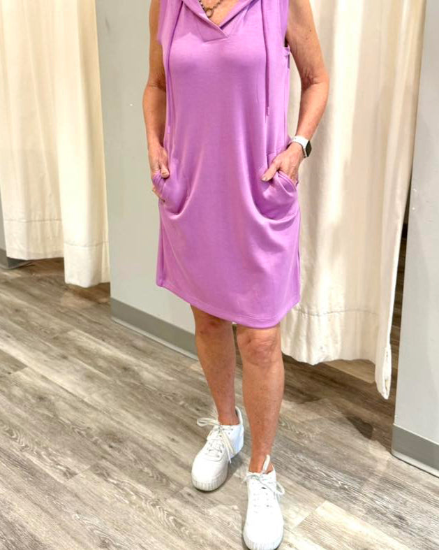 This sleeveless black dress is the epitome of casual sophistication and comfort. Featuring a relaxed fit and a sporty hood with adjustable drawstrings, it blends modern athleisure with classic elegance. The lightweight fabric drapes effortlessly, while the side pockets add both practicality and style. Perfect for dressing up with accessories or keeping it laid-back with sneakers, this versatile piece is a wardrobe essential for any occasion. Purple